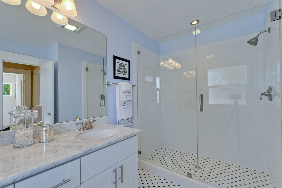 Idée de décoration pour une salle de bain principale tradition de taille moyenne avec un placard à porte shaker, des portes de placard blanches, une douche d'angle, WC séparés, un carrelage noir et blanc, des carreaux de béton, un mur bleu, un lavabo encastré et un plan de toilette en granite.