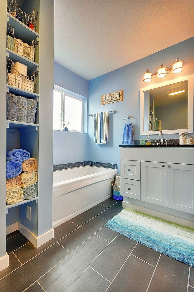 Inspiration for a mid-sized timeless 3/4 beige tile porcelain tile alcove shower remodel in San Francisco with shaker cabinets, white cabinets, a two-piece toilet, blue walls, an undermount sink and granite countertops