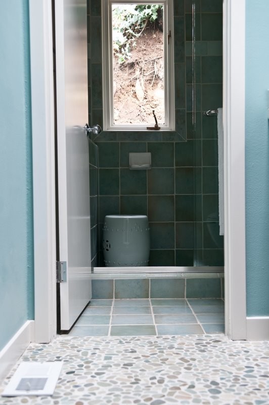 Cette image montre une salle de bain design en bois foncé avec un placard à porte plane, WC séparés, un carrelage beige, un carrelage gris, une plaque de galets, un mur bleu, un sol en galet, une vasque et un plan de toilette en quartz.
