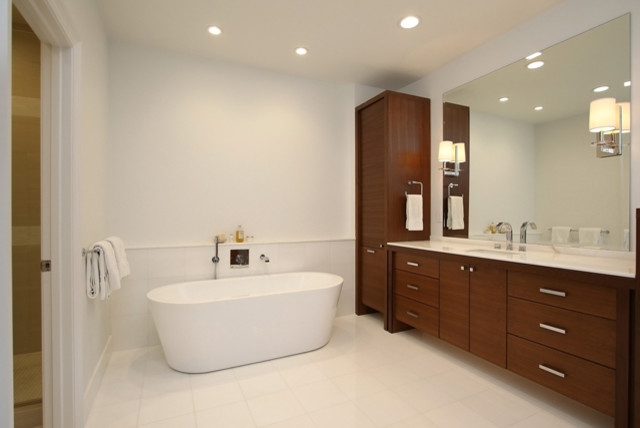 Modernes Badezimmer En Suite mit flächenbündigen Schrankfronten, dunklen Holzschränken, freistehender Badewanne, Duschnische, weißen Fliesen, weißer Wandfarbe und integriertem Waschbecken in Houston