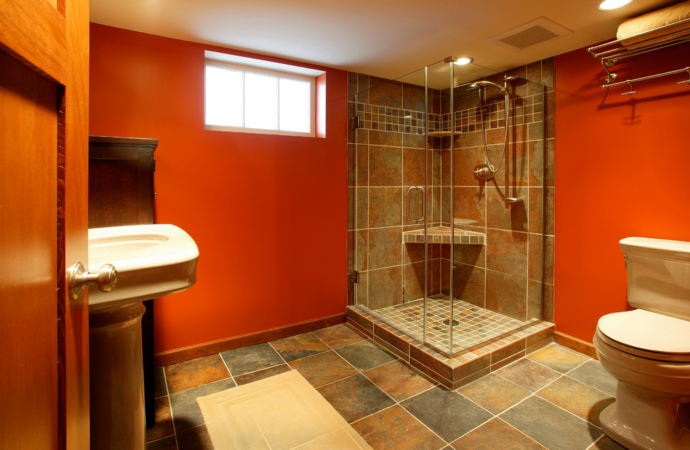 Esempio di una stanza da bagno con doccia tradizionale di medie dimensioni con doccia ad angolo, WC monopezzo, piastrelle multicolore, piastrelle in ceramica, pareti arancioni, pavimento in gres porcellanato e lavabo a colonna
