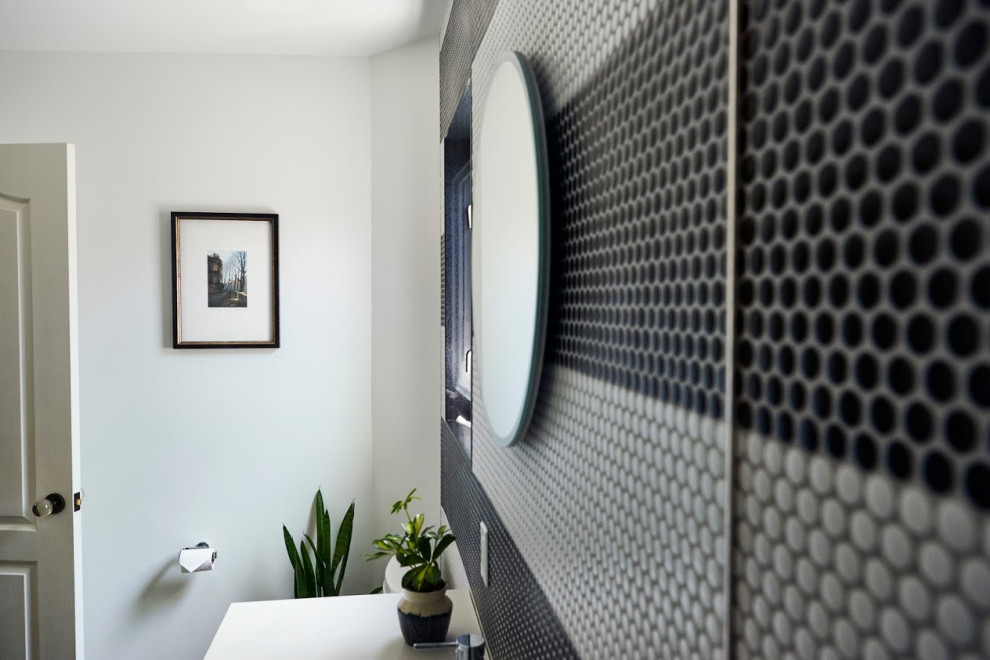 На фото: ванная комната в стиле модернизм с светлыми деревянными фасадами, черно-белой плиткой и белой столешницей с