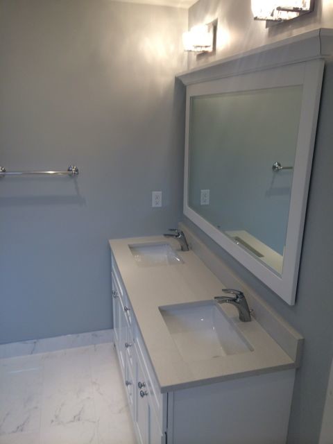 На фото: ванная комната среднего размера в классическом стиле с врезной раковиной, фасадами с утопленной филенкой, белыми фасадами, угловым душем, унитазом-моноблоком, белой плиткой, серыми стенами и душевой кабиной с