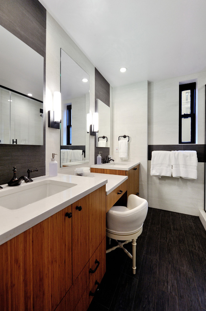 Cette photo montre une salle de bain principale tendance en bois brun de taille moyenne avec un lavabo encastré, une douche d'angle, WC à poser, un carrelage gris, des carreaux de porcelaine, un mur gris, un sol en carrelage de porcelaine, un plan de toilette en quartz et un placard à porte plane.