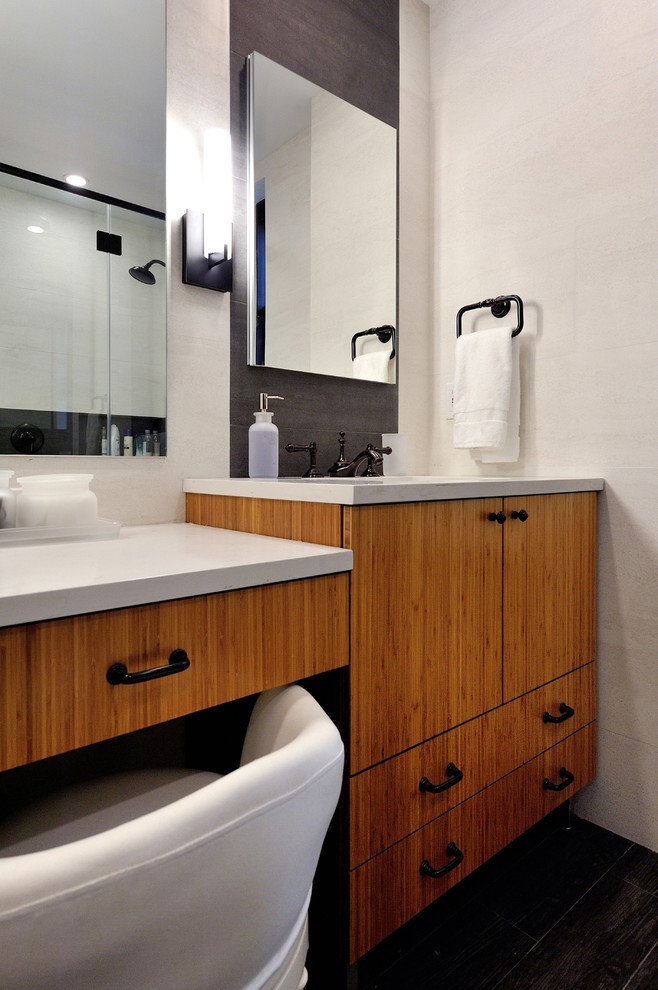 Réalisation d'une salle de bain principale design en bois brun de taille moyenne avec un placard en trompe-l'oeil, une douche d'angle, WC à poser, un carrelage gris, des carreaux de porcelaine, un mur gris, un sol en carrelage de porcelaine, un lavabo encastré et un plan de toilette en quartz.
