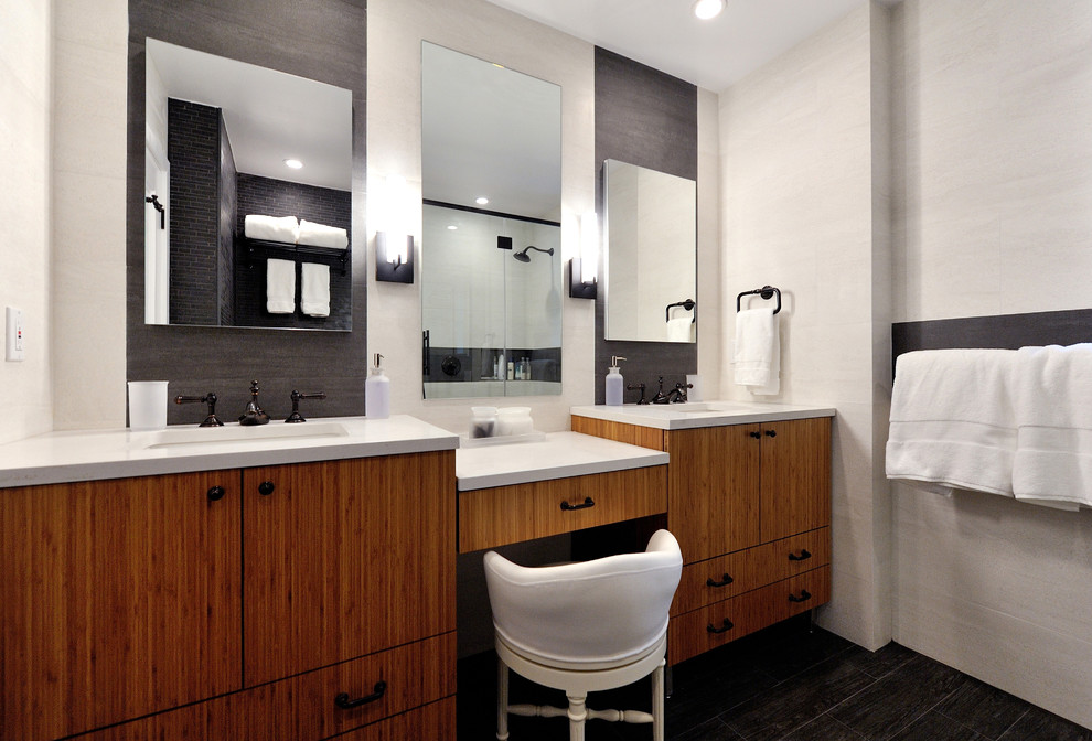 Photo of a medium sized contemporary ensuite bathroom in New York with freestanding cabinets, medium wood cabinets, a corner shower, a one-piece toilet, grey tiles, porcelain tiles, grey walls, porcelain flooring, a submerged sink and quartz worktops.