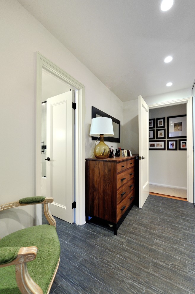 Photo of a medium sized contemporary ensuite bathroom in New York with freestanding cabinets, medium wood cabinets, a corner shower, a one-piece toilet, grey tiles, porcelain tiles, grey walls, porcelain flooring, a submerged sink and quartz worktops.