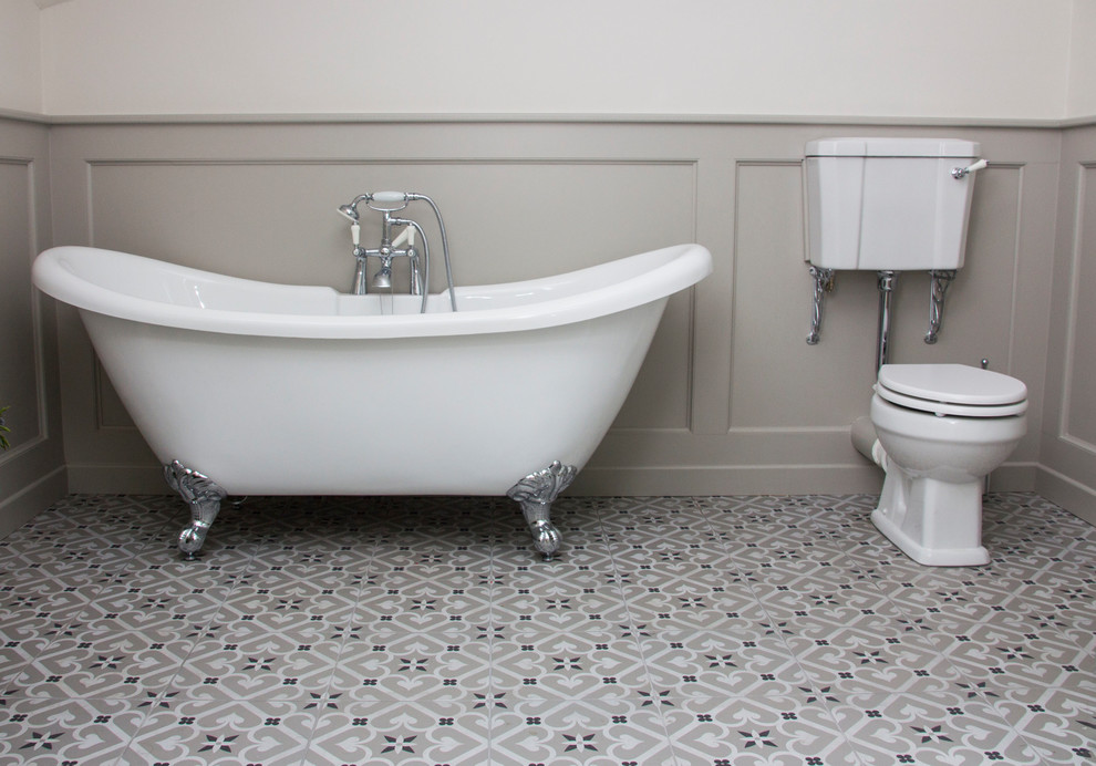 Cette photo montre une salle de bain chic avec un placard en trompe-l'oeil, des portes de placard grises, une baignoire indépendante, un combiné douche/baignoire, WC séparés, un carrelage gris, des carreaux de céramique, un mur gris, carreaux de ciment au sol, un lavabo intégré et un sol gris.