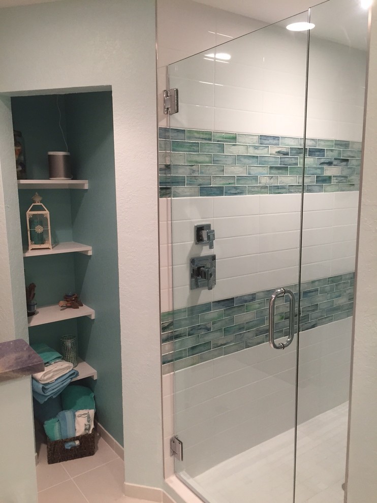 Immagine di una stanza da bagno padronale tropicale di medie dimensioni con doccia alcova, piastrelle blu e piastrelle di vetro