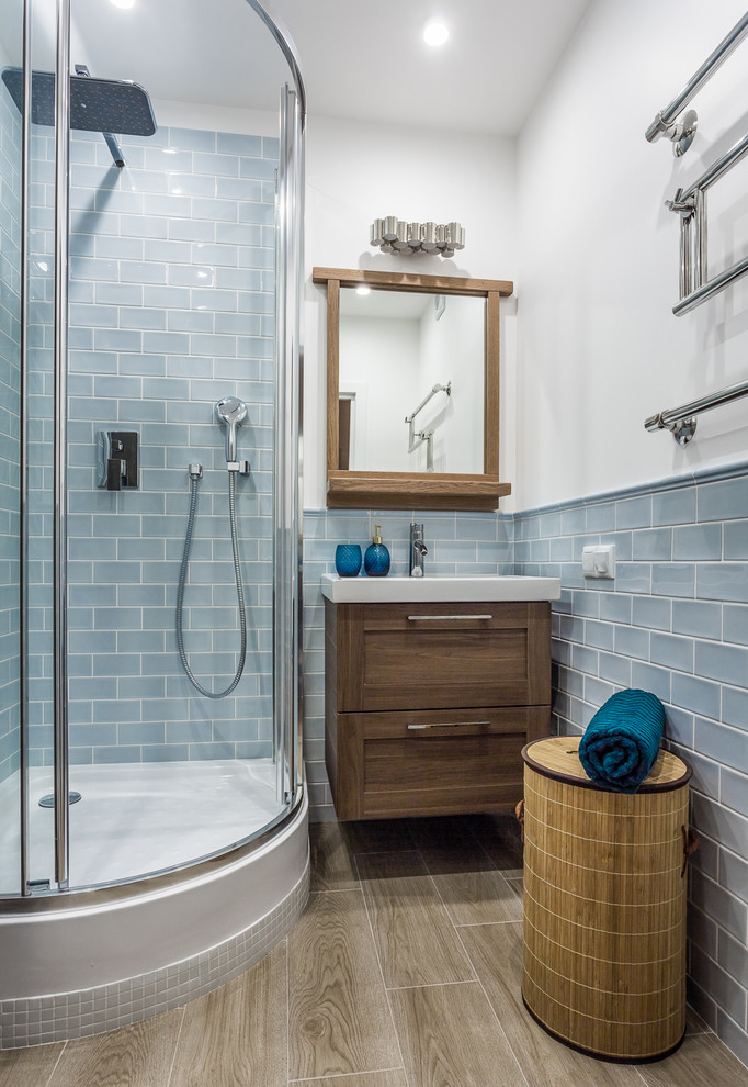 Идея дизайна: маленькая ванная комната в морском стиле с угловым душем, синей плиткой, керамической плиткой, полом из керамической плитки, фасадами в стиле шейкер, темными деревянными фасадами, белыми стенами, душевой кабиной, монолитной раковиной и душем с распашными дверями для на участке и в саду