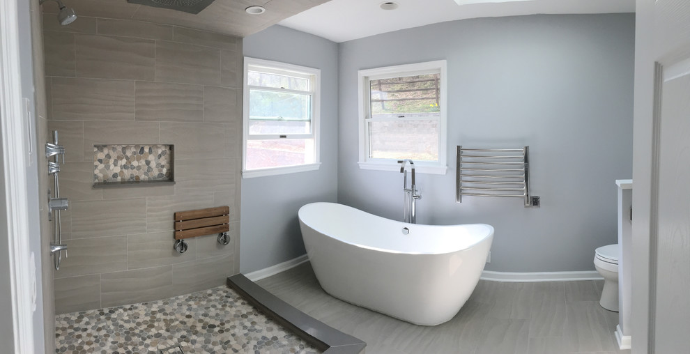 This is an example of a medium sized contemporary ensuite bathroom in New York with a freestanding bath, a corner shower, beige tiles, ceramic tiles, blue walls and ceramic flooring.