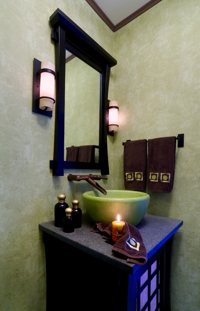 Ejemplo de aseo de estilo zen con lavabo sobreencimera, paredes verdes, armarios tipo mueble y puertas de armario de madera en tonos medios