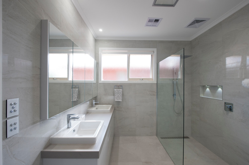 На фото: большая главная ванная комната в современном стиле с зелеными фасадами, гидромассажной ванной, открытым душем, серой плиткой, керамогранитной плиткой, полом из керамогранита, накладной раковиной и столешницей из искусственного кварца