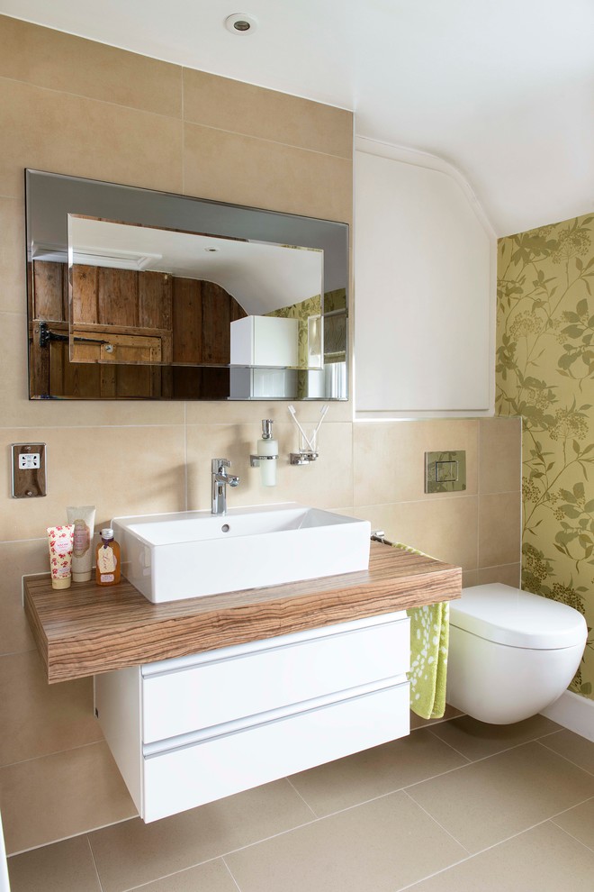 Medium sized contemporary ensuite bathroom in Other with a console sink, flat-panel cabinets, white cabinets, laminate worktops, a shower/bath combination, a wall mounted toilet, beige tiles, porcelain tiles, beige walls and lino flooring.