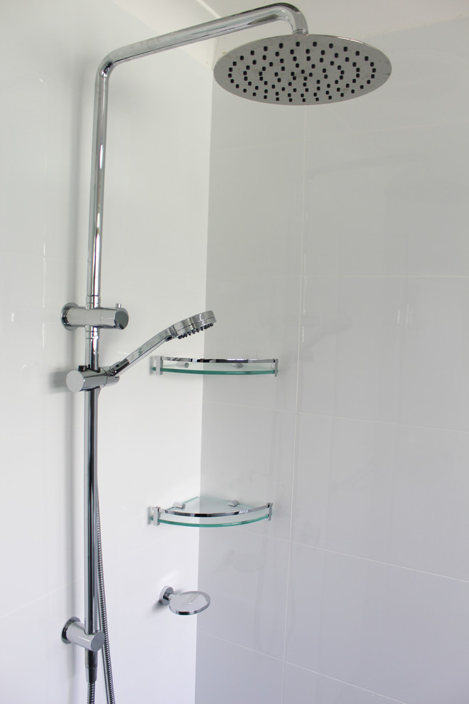 This is an example of a large contemporary ensuite bathroom in Perth with flat-panel cabinets, white cabinets, a freestanding bath, a corner shower, a one-piece toilet, white tiles, porcelain tiles, black walls, porcelain flooring, a vessel sink, engineered stone worktops, black floors, a hinged door and grey worktops.