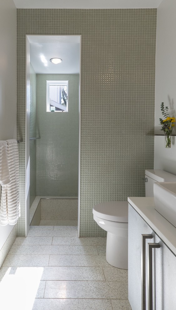 Inspiration för små moderna en-suite badrum, med ett fristående handfat, släta luckor, bänkskiva i akrylsten, en dusch i en alkov, en toalettstol med hel cisternkåpa, glaskakel, vita väggar, grå skåp, grön kakel, grått golv, med dusch som är öppen och terrazzogolv