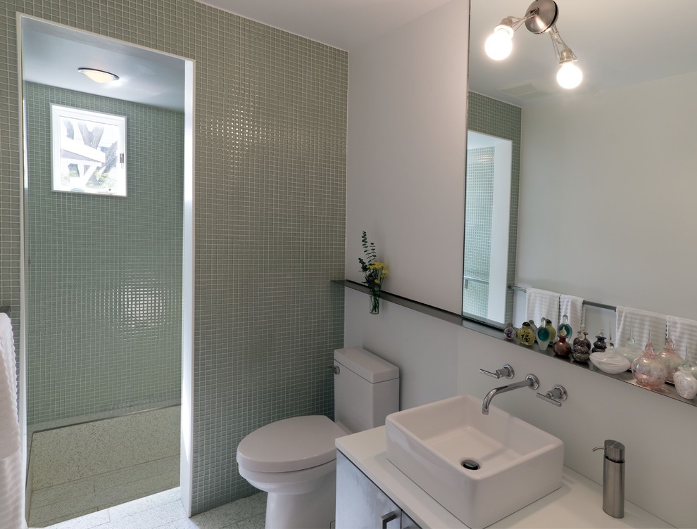 Стильный дизайн: маленькая главная ванная комната в стиле модернизм с настольной раковиной, плоскими фасадами, столешницей из искусственного камня, душем в нише, унитазом-моноблоком, стеклянной плиткой, белыми стенами, серыми фасадами, зеленой плиткой, полом из терраццо, серым полом и открытым душем для на участке и в саду - последний тренд