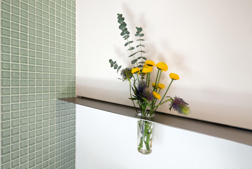 Idée de décoration pour une petite douche en alcôve principale minimaliste avec un placard à porte plane, une vasque, un plan de toilette en surface solide, WC à poser, des plaques de verre et un mur blanc.