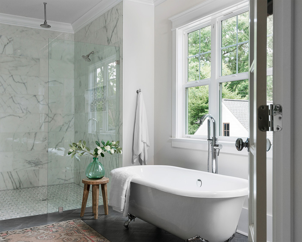 Cette photo montre une salle de bain principale chic avec une baignoire sur pieds, une douche d'angle, un carrelage blanc, un mur blanc et un sol gris.
