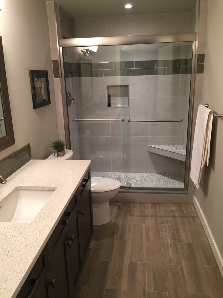 Exemple d'une salle de bain chic en bois foncé de taille moyenne avec un mur gris, un sol en bois brun, un placard à porte shaker et un lavabo encastré.