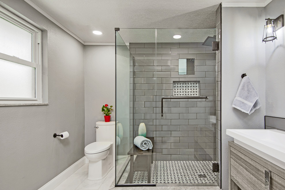 Пример оригинального дизайна: главная ванная комната среднего размера в современном стиле с плоскими фасадами, светлыми деревянными фасадами, угловым душем, унитазом-моноблоком, серой плиткой, плиткой кабанчик, серыми стенами, полом из керамогранита, настольной раковиной, столешницей из талькохлорита, белым полом, душем с распашными дверями, белой столешницей, нишей, тумбой под одну раковину и напольной тумбой