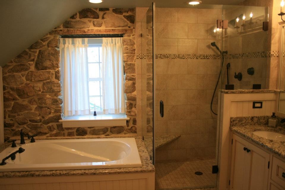 Lantlig inredning av ett stort en-suite badrum, med skåp i shakerstil, vita skåp, ett hörnbadkar, en hörndusch, en toalettstol med separat cisternkåpa, beige väggar, klinkergolv i terrakotta, ett undermonterad handfat och granitbänkskiva