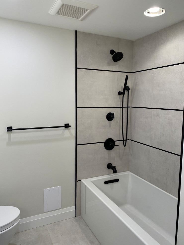 Mid-sized minimalist 3/4 beige tile and porcelain tile porcelain tile, beige floor and single-sink drop-in bathtub photo in New York with flat-panel cabinets, distressed cabinets, a two-piece toilet, beige walls, quartz countertops, white countertops, a niche and a floating vanity
