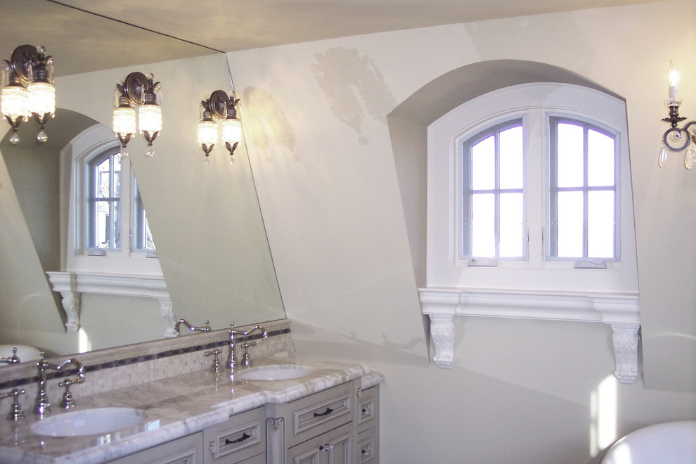 Ispirazione per una stanza da bagno con doccia mediterranea di medie dimensioni con lavabo da incasso, ante a filo, ante grigie, top in marmo, vasca ad angolo, piastrelle multicolore, piastrelle a mosaico e pareti beige