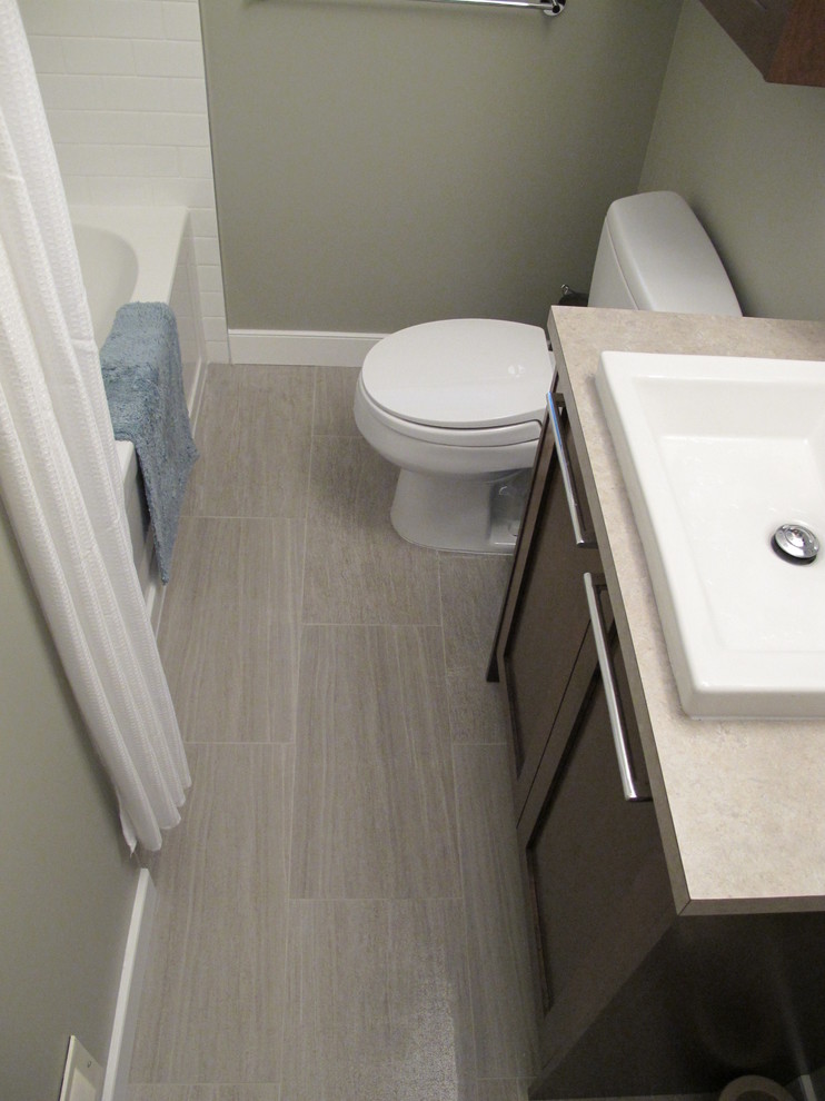 Cette photo montre une salle de bain moderne en bois foncé de taille moyenne pour enfant avec une vasque, un placard à porte plane, un plan de toilette en quartz, une baignoire en alcôve, WC séparés, un carrelage gris, des carreaux de porcelaine, un mur gris et un sol en carrelage de terre cuite.