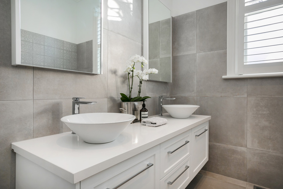 Immagine di una stanza da bagno contemporanea con WC monopezzo, pareti bianche, pavimento in gres porcellanato, lavabo a bacinella e top in quarzo composito