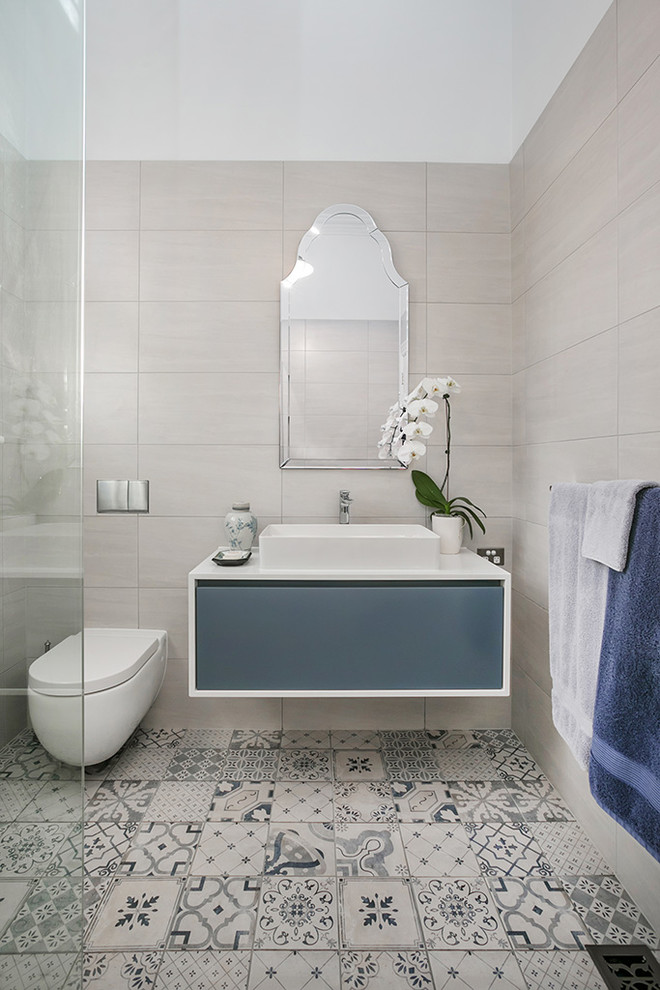 Idéer för att renovera ett funkis badrum, med klinkergolv i porslin, ett fristående handfat, bänkskiva i kvarts, släta luckor, blå skåp, en vägghängd toalettstol, beige väggar och med dusch som är öppen