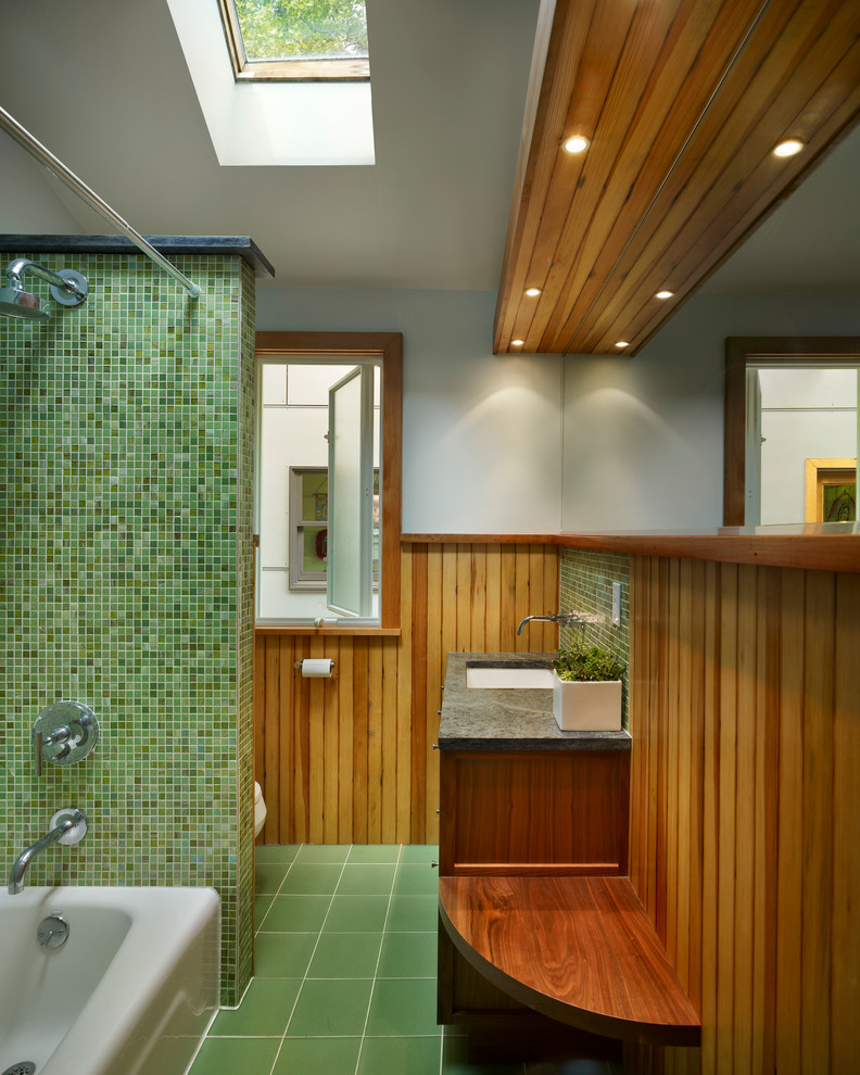 ニューヨークにある広いコンテンポラリースタイルのおしゃれな浴室 (落し込みパネル扉のキャビネット、濃色木目調キャビネット、アルコーブ型浴槽、アルコーブ型シャワー、緑のタイル、モザイクタイル、グレーの壁、磁器タイルの床、アンダーカウンター洗面器、ライムストーンの洗面台、緑の床、シャワーカーテン、グレーの洗面カウンター) の写真