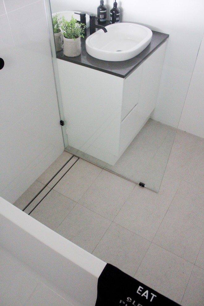 Example of a small minimalist kids' white tile and ceramic tile porcelain tile and gray floor bathroom design in Perth with flat-panel cabinets, white cabinets, a one-piece toilet, white walls, a vessel sink, quartz countertops and black countertops