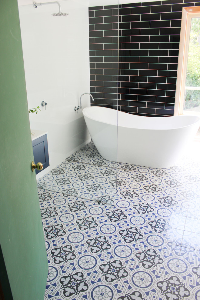 Стильный дизайн: большая главная ванная комната с фасадами в стиле шейкер, синими фасадами, отдельно стоящей ванной, душевой комнатой, унитазом-моноблоком, белой плиткой, керамической плиткой, белыми стенами, полом из мозаичной плитки, настольной раковиной, столешницей из искусственного кварца, разноцветным полом, открытым душем и белой столешницей - последний тренд