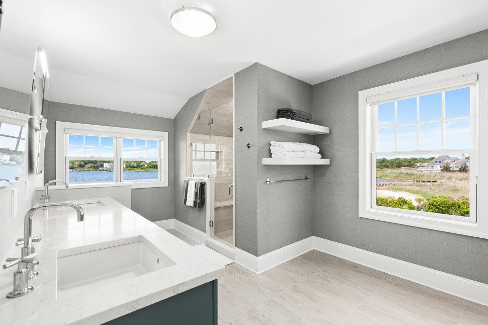 Beach style master gray tile wood-look tile floor, double-sink and wallpaper bathroom photo in New York with a drop-in sink, quartz countertops, a hinged shower door, white countertops and a built-in vanity