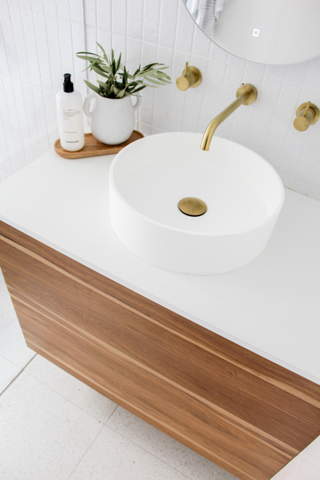 Design ideas for a medium sized modern bathroom in Perth with flat-panel cabinets, dark wood cabinets, a freestanding bath, white tiles, ceramic tiles, white walls, porcelain flooring, a vessel sink, engineered stone worktops, white floors, an open shower and white worktops.