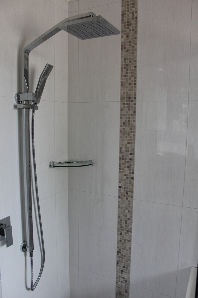 Photo of a small modern ensuite bathroom in Perth with freestanding cabinets, light wood cabinets, a corner shower, a one-piece toilet, grey tiles, ceramic tiles, grey walls, ceramic flooring, a vessel sink and engineered stone worktops.