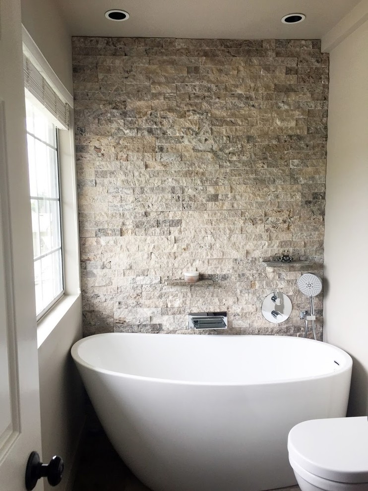 Example of a small minimalist stone tile freestanding bathtub design in Vancouver