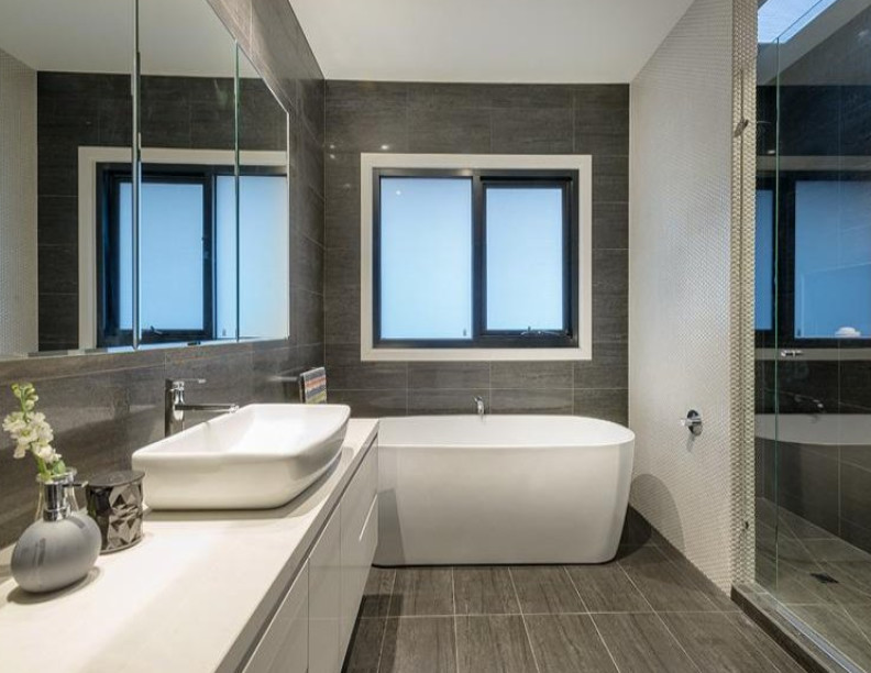 Modernes Badezimmer mit weißen Schränken, freistehender Badewanne, weißen Fliesen, Mosaikfliesen, weißer Wandfarbe, Porzellan-Bodenfliesen und Aufsatzwaschbecken in Melbourne