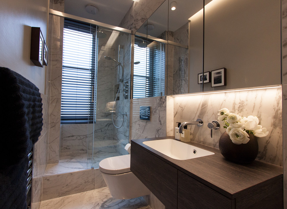 Bathroom - small contemporary 3/4 white tile and marble tile porcelain tile and white floor bathroom idea in Edinburgh with brown cabinets, a wall-mount toilet, gray walls, a wall-mount sink and laminate countertops