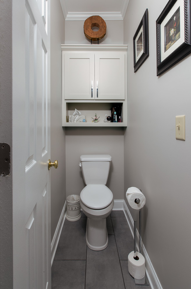 Inredning av ett klassiskt mellanstort svart svart toalett, med luckor med infälld panel, grå skåp, en toalettstol med separat cisternkåpa, grå kakel, keramikplattor, grå väggar, klinkergolv i keramik, ett undermonterad handfat, granitbänkskiva och grått golv