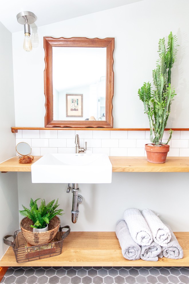 Rustikales Duschbad mit offenen Schränken, weißer Wandfarbe, Wandwaschbecken, Waschtisch aus Holz, grauem Boden und brauner Waschtischplatte in Austin