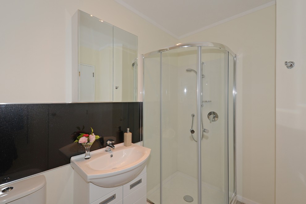 Foto di una piccola stanza da bagno minimalista con consolle stile comò, ante bianche, doccia ad angolo, WC a due pezzi, piastrelle nere, pavimento in vinile e lavabo a bacinella