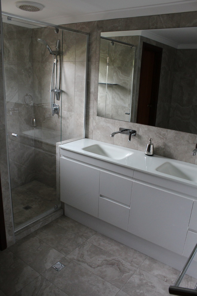 Bild på ett stort funkis en-suite badrum, med luckor med profilerade fronter, vita skåp, en dusch i en alkov, flerfärgad kakel, porslinskakel, flerfärgade väggar, klinkergolv i porslin, ett integrerad handfat och bänkskiva i glas