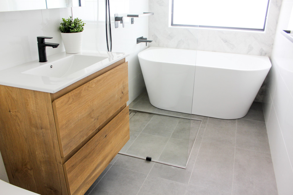 Bathroom - mid-sized modern master white tile and ceramic tile porcelain tile and gray floor bathroom idea in Perth with flat-panel cabinets, light wood cabinets, a one-piece toilet, white walls, an integrated sink, quartz countertops and white countertops