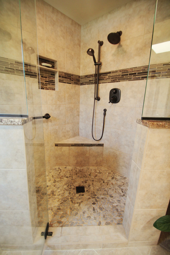 Пример оригинального дизайна: большая главная ванная комната в классическом стиле с угловым душем, плоскими фасадами, темными деревянными фасадами, раздельным унитазом, бежевой плиткой, удлиненной плиткой, бежевыми стенами, накладной раковиной, столешницей из гранита, угловой ванной, полом из галечной плитки, бежевым полом и душем с распашными дверями