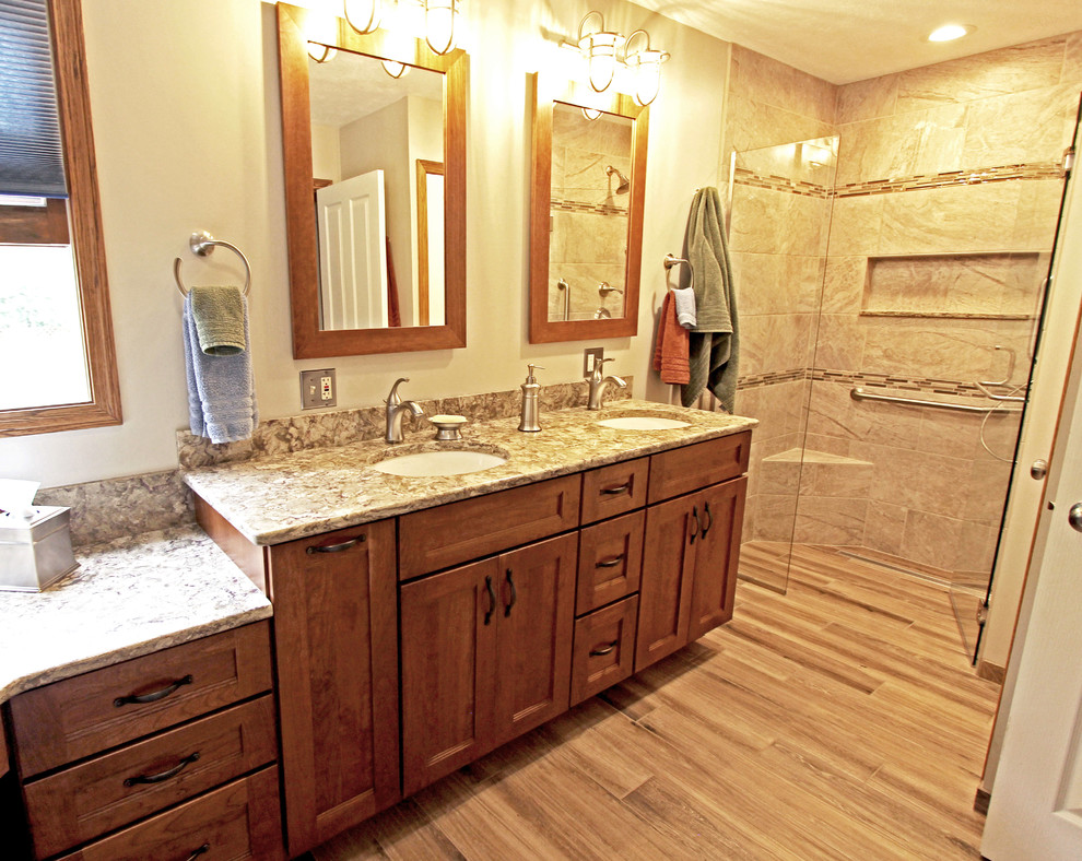 Medium sized traditional ensuite bathroom in Cleveland with recessed-panel cabinets, medium wood cabinets, a built-in shower, beige tiles, porcelain tiles, beige walls, medium hardwood flooring, a submerged sink and engineered stone worktops.