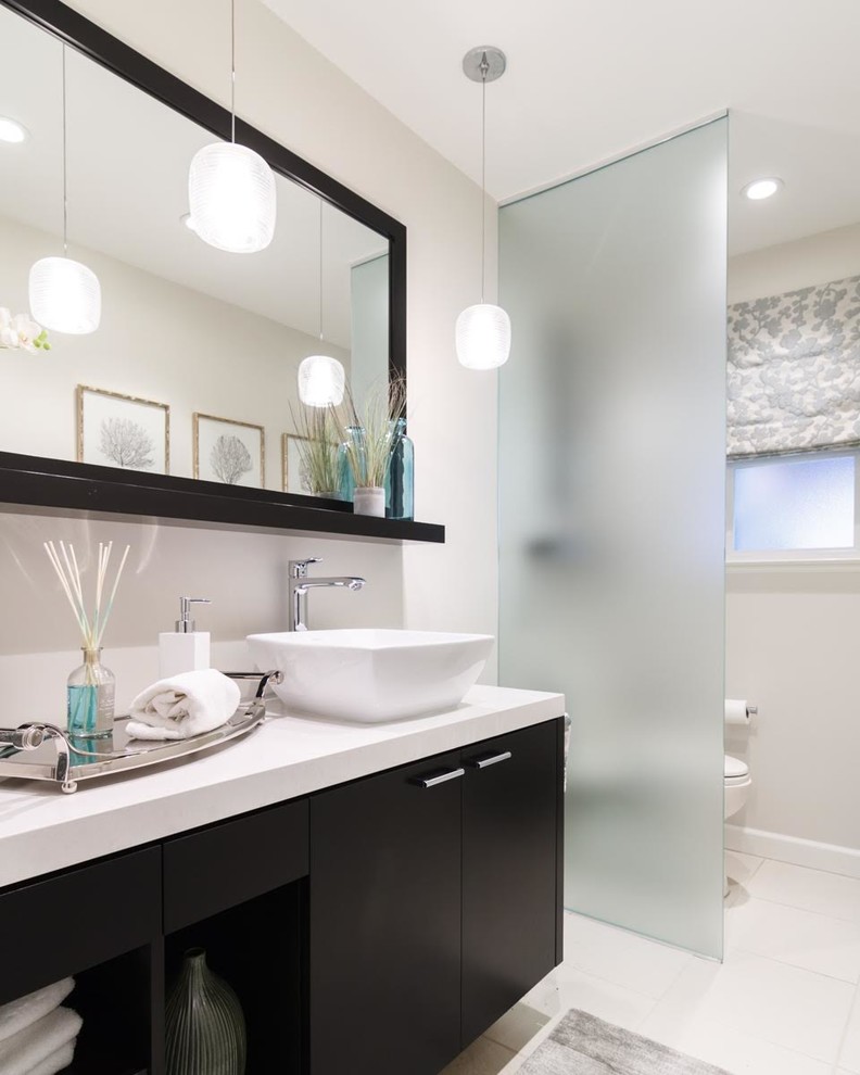 Example of a mid-sized trendy 3/4 white tile and stone slab porcelain tile and white floor open shower design in San Francisco with flat-panel cabinets, black cabinets, a two-piece toilet, gray walls, a vessel sink and solid surface countertops