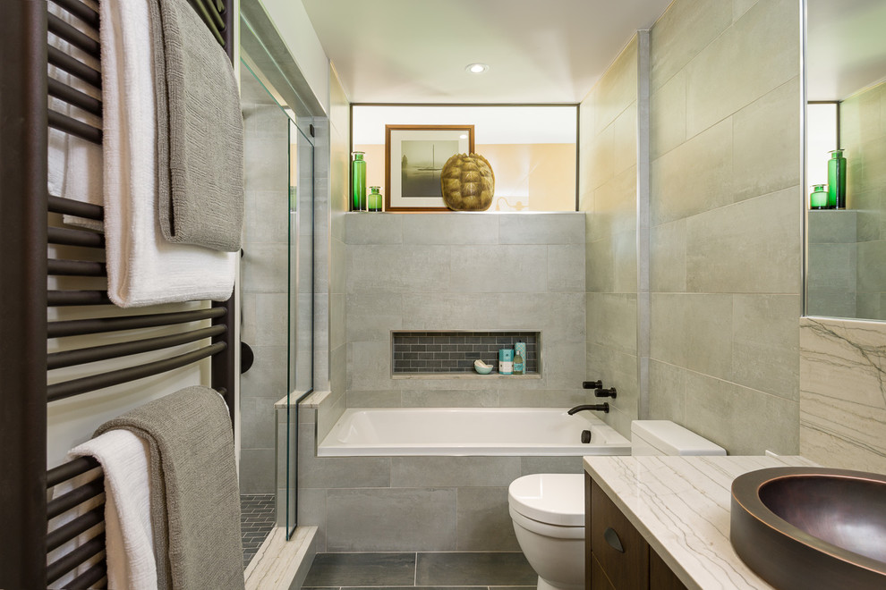 Идея дизайна: ванная комната среднего размера в стиле модернизм с настольной раковиной, фасадами цвета дерева среднего тона, мраморной столешницей, накладной ванной, угловым душем, унитазом-моноблоком, серой плиткой, бежевыми стенами и душевой кабиной