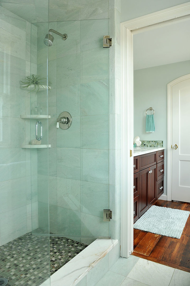 Inredning av ett eklektiskt badrum, med ett undermonterad handfat, luckor med profilerade fronter, skåp i mörkt trä, marmorbänkskiva, en dusch i en alkov, en toalettstol med separat cisternkåpa, grön kakel och stenkakel